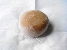 A tan colored, rounded flat mochi cake