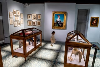 A gallery inside the Museon Arlaten, museum of Provence, with displays of regional material culture arranged along the room.