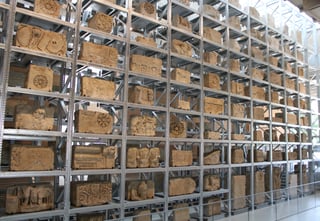 A tall museum wall filled with hundreds of carved and inscribed Roman stone blocks stacked in a regular grid, the lettering sharp under even light.