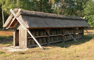 A long open thatched shelter on the heath, its two shelves filled with rows of coiled straw skeps.