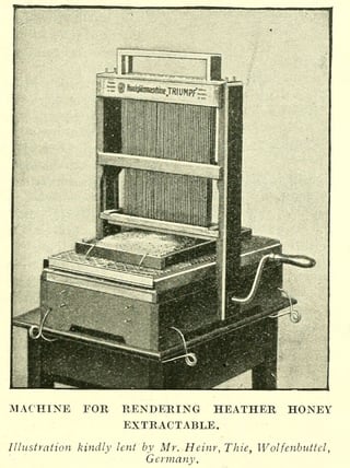 An old photograph of a hand-cranked bench machine with a frame of hanging needles above a tray holding a comb.