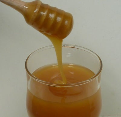 Amber honey milky drizzling into a wind glass.