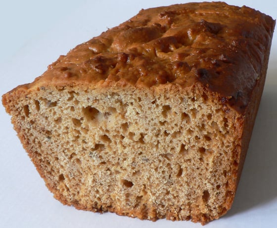 The cut end of a loaf of honey gingerbread with a glossy dark-brown crust and a soft, open crumb.