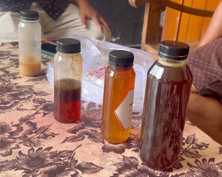 Four different sized bottles of stingless bee honey sitting on a table.