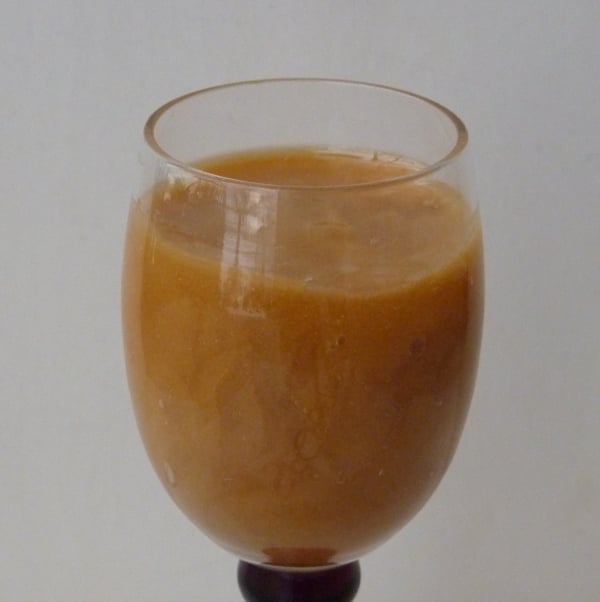 Dark, partly crystalized honey in a wine glass.